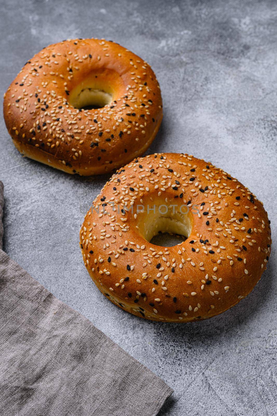 Fresh Bagels with Sesame set, on gray stone table background by Ilianesolenyi