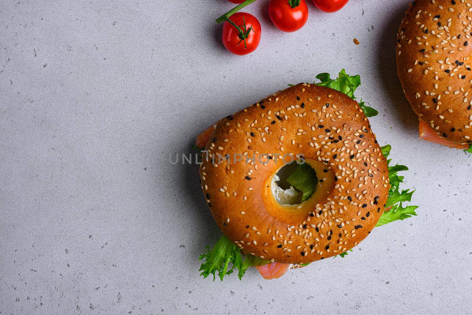 Bagel with red fish and soft cheese, on gray stone table background, top view flat lay, with copy space for text by Ilianesolenyi