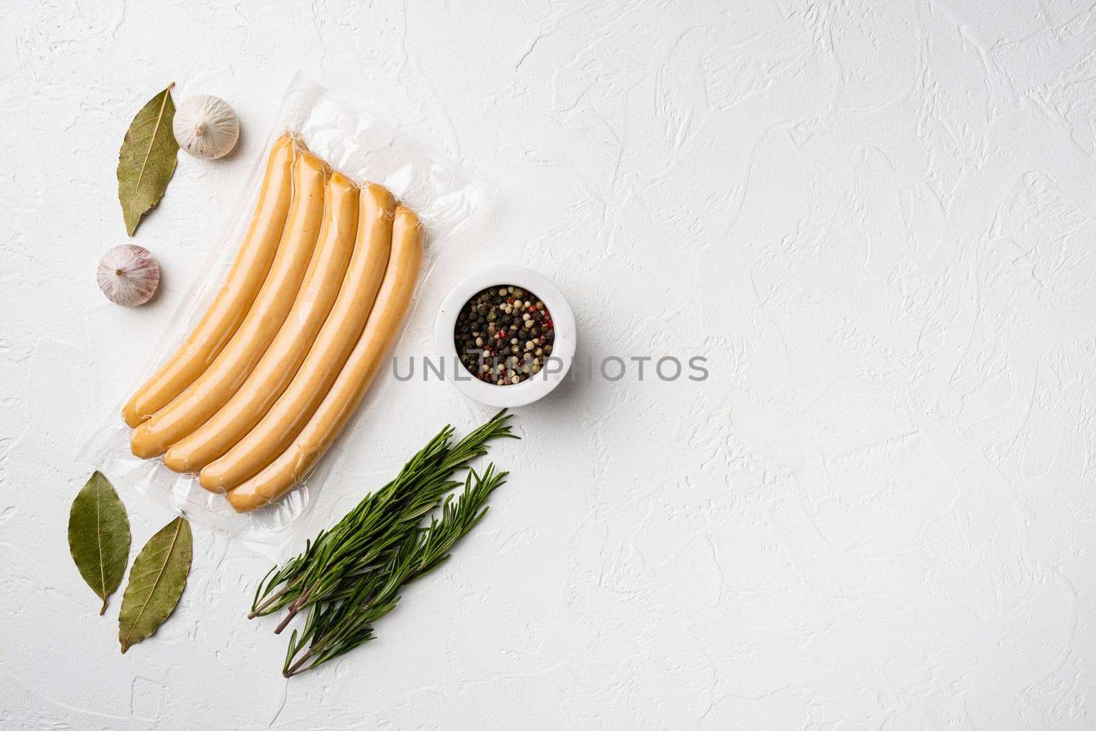 A vacuum package of hotdogs set, on white stone table background, top view flat lay, with copy space for text