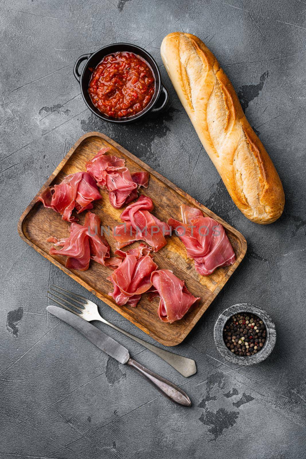 Jamon serrano. Traditional Spanish ham set, on gray stone table background, top view flat lay, with copy space for text by Ilianesolenyi