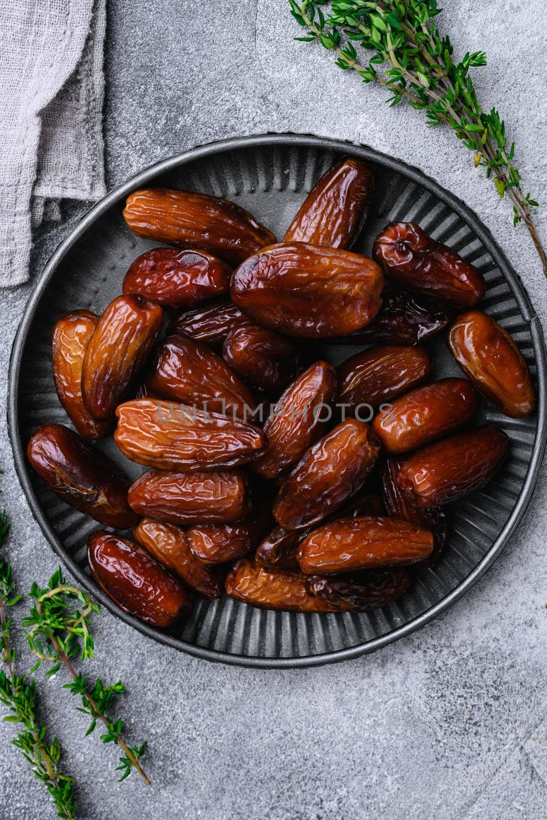 Ramadan dates is traditional food for iftar in islamic world, on gray stone table background, top view flat lay