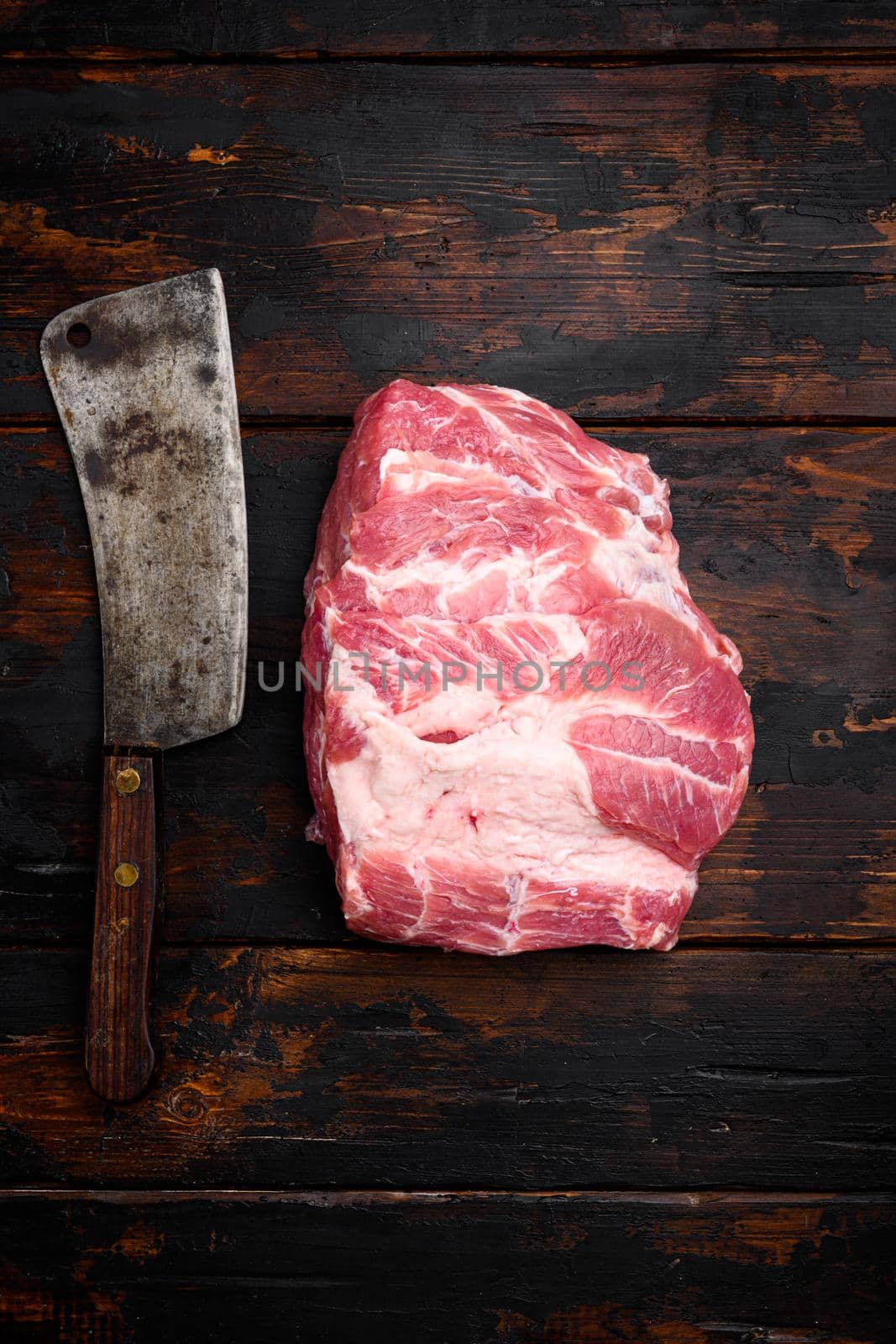 Fresh raw pork neck meat , with old butcher cleaver knife, on old dark wooden table background, top view flat lay, with copy space for text by Ilianesolenyi