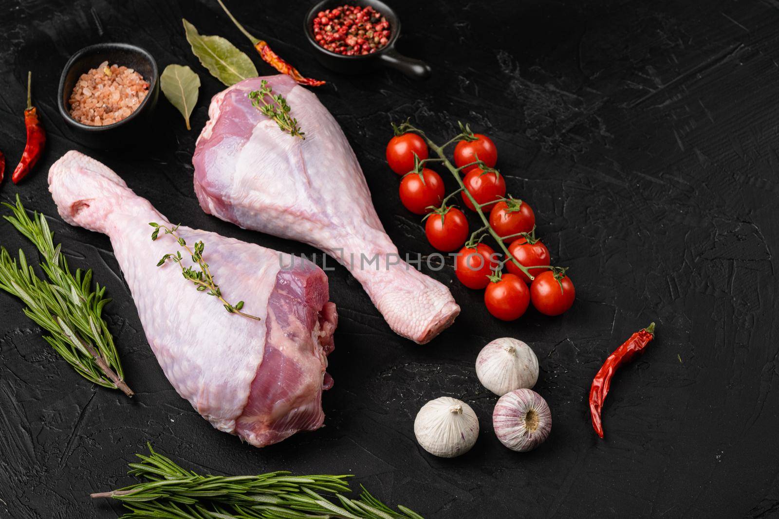 Turkey meat, raw thigh with spices set, on black dark stone table background, top view flat lay, with copy space for text