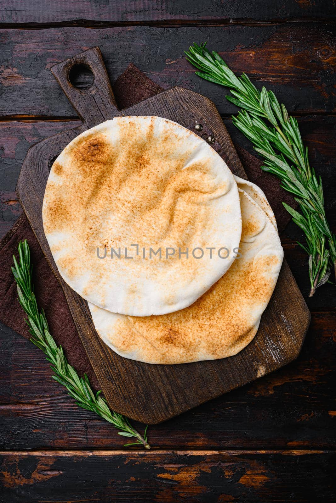 Pita bread on kitchen, on old dark wooden table background, top view flat lay