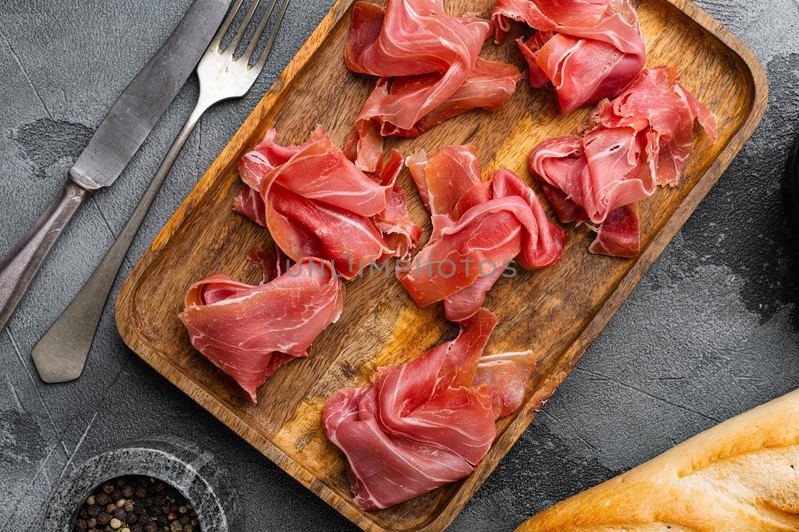 Fresh slices jamon set, on gray stone table background, top view flat lay by Ilianesolenyi