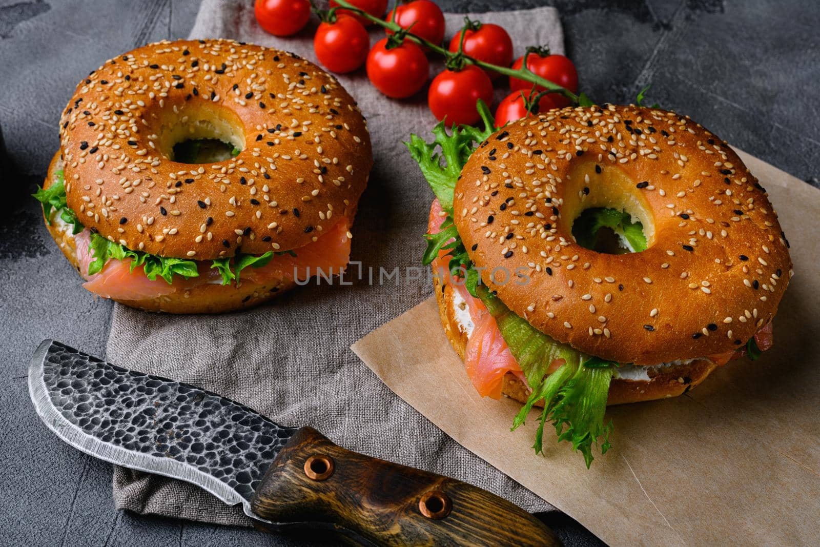 Traditional bagel with salmon and cream cheese, on gray stone table background by Ilianesolenyi