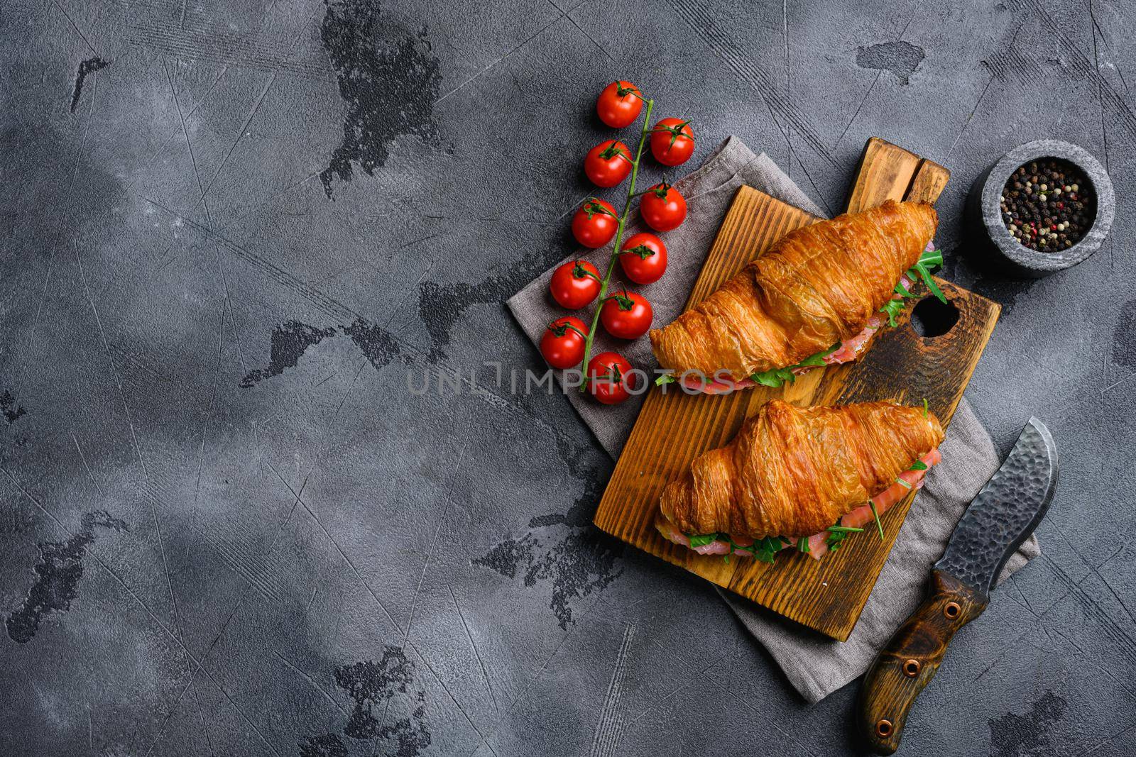 Croissant sandwich with salmon set, on gray stone table background, top view flat lay, with copy space for text