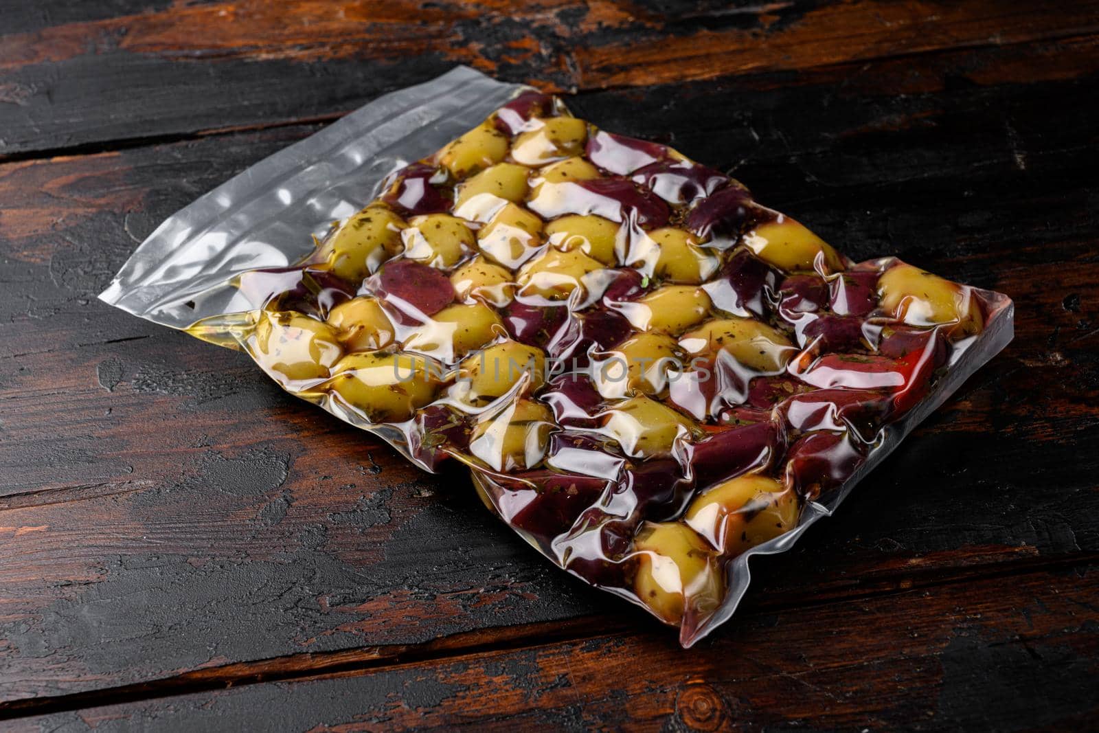Pickled Olives in Vacuum Sealed Bag, on old dark wooden table background by Ilianesolenyi