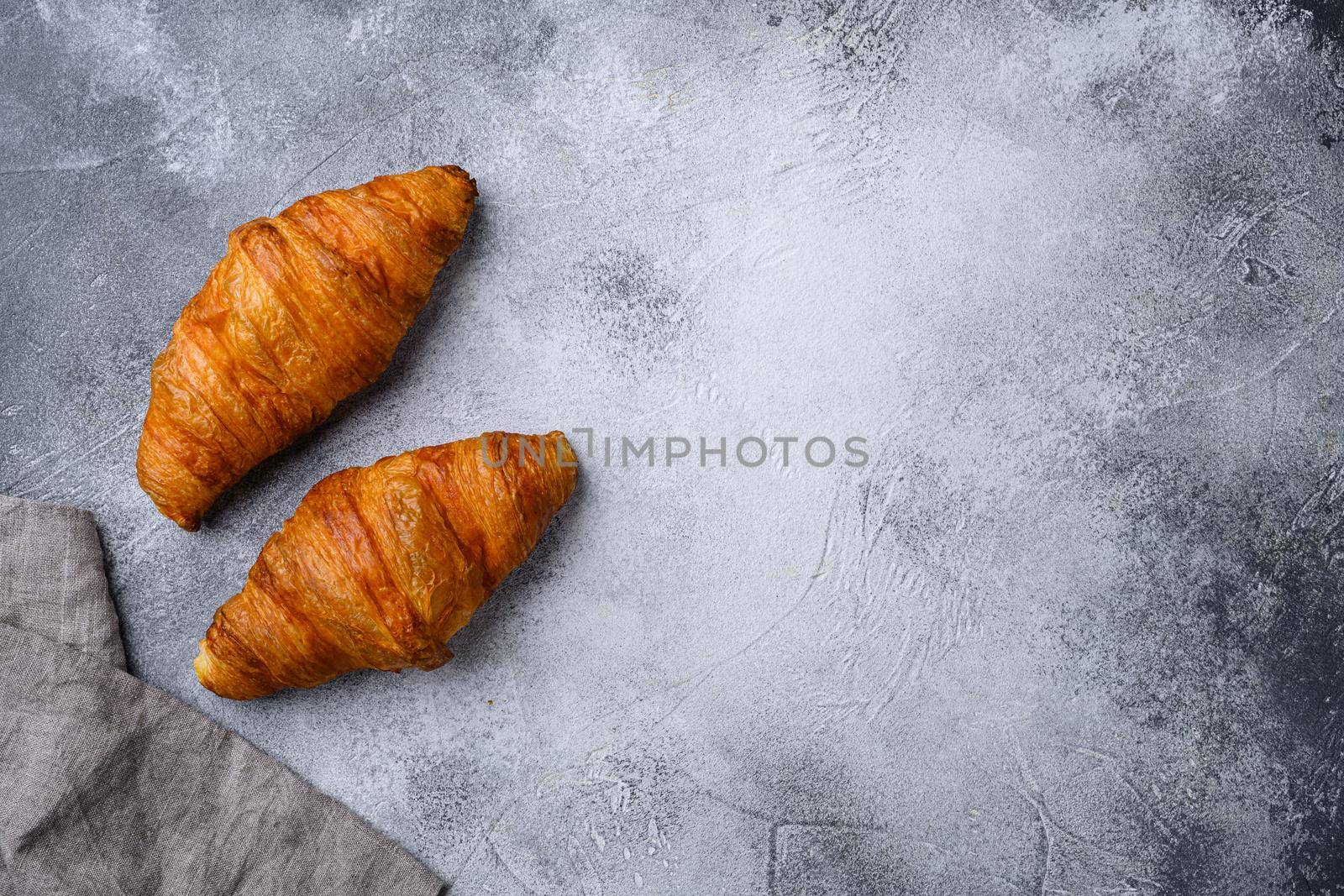 Fresh croissants on table set, on gray stone table background, top view flat lay, with copy space for text by Ilianesolenyi