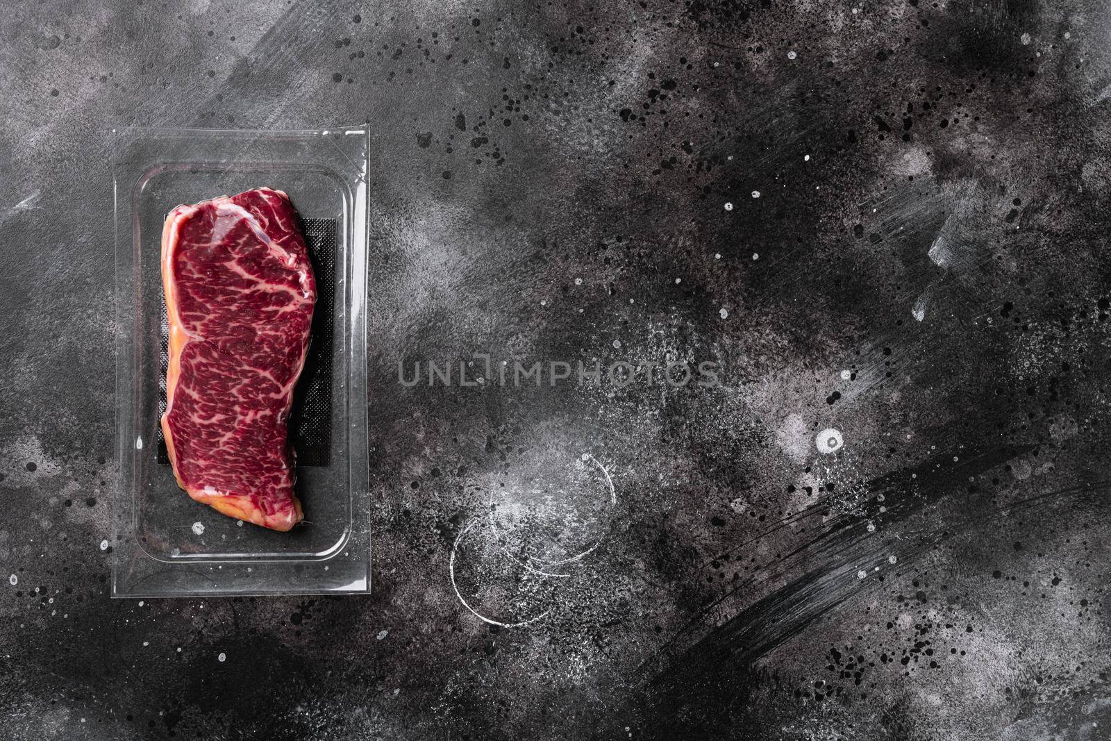 Meat in a package set, on black dark stone table background, top view flat lay, with copy space for text