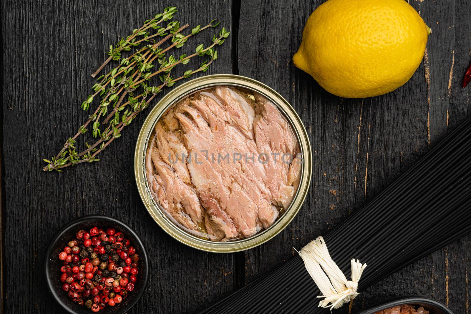 Tuna canned fish seafood set, on black wooden table background, top view flat lay
