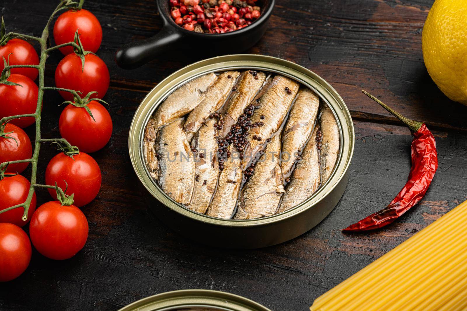 Canned sardines. Sea fish in tin can set, on old dark wooden table background