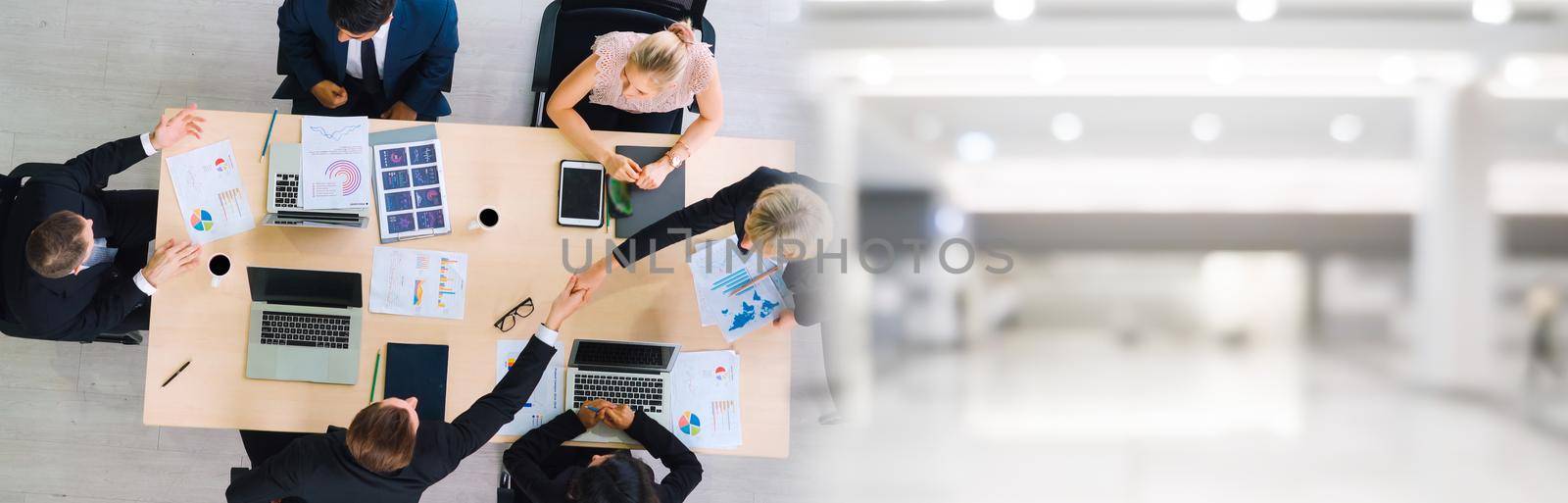 Business people group meeting shot from top widen view in office . Profession businesswomen, businessmen and office workers working in team conference with project planning document on meeting table .