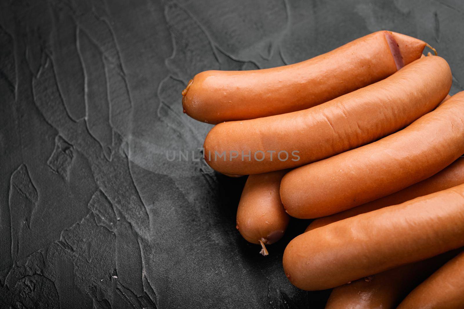 Boiled sausage, on black dark stone table background, with copy space for text by Ilianesolenyi