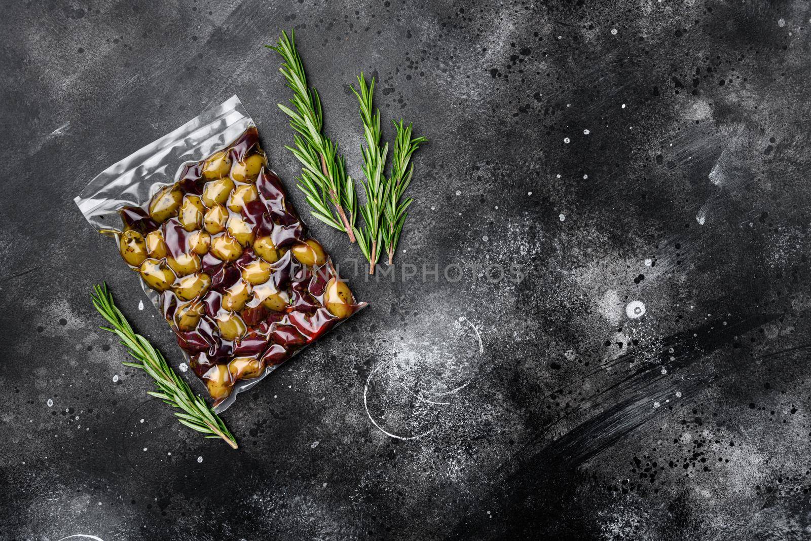 Greece olives in plastic pack, on black dark stone table background, top view flat lay, with copy space for text by Ilianesolenyi
