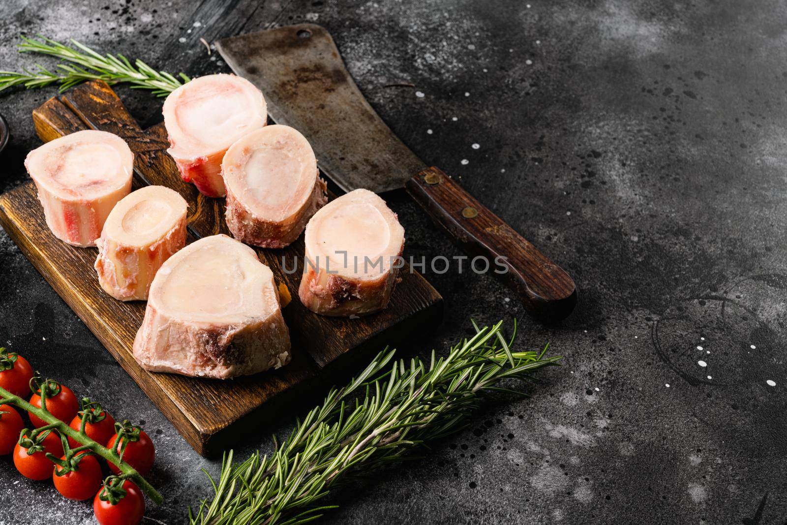 Raw caw bones butcher cut, on black dark stone table background, with copy space for text by Ilianesolenyi