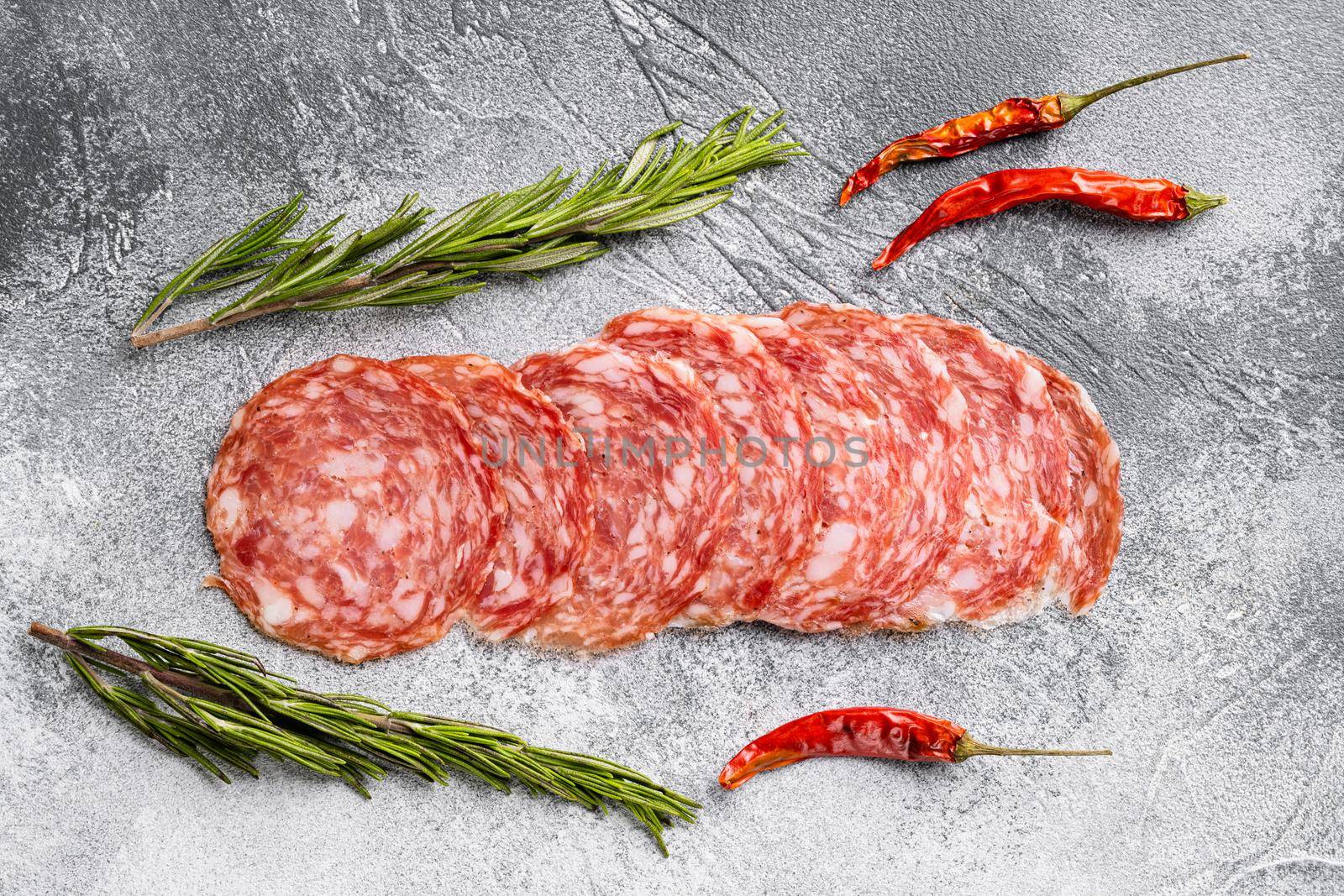 Salami smoked sausage, on gray stone table background, top view flat lay by Ilianesolenyi