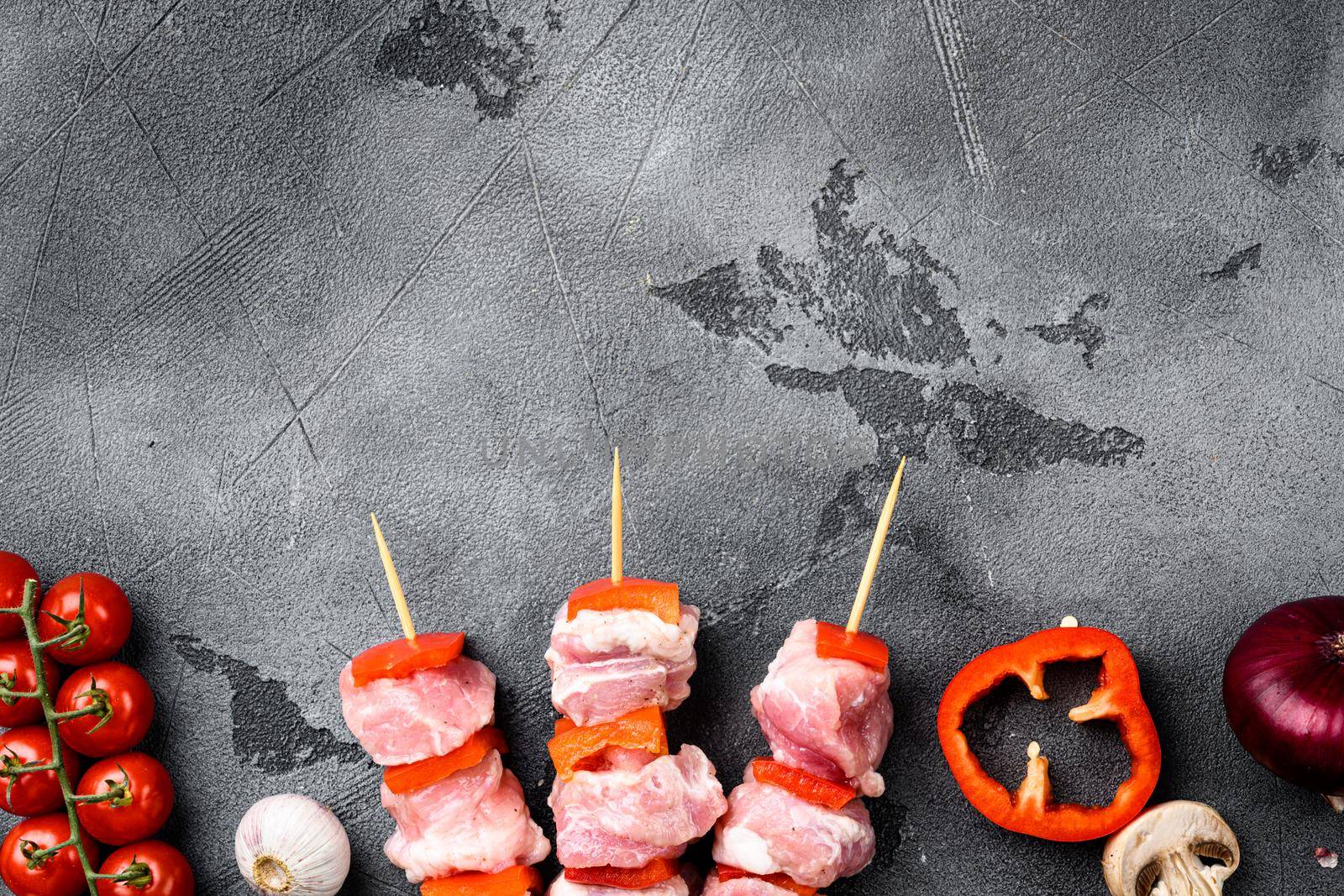 Skewer with raw kebab pork meat and onion set, top view flat lay, with copy space for text, on gray stone table background