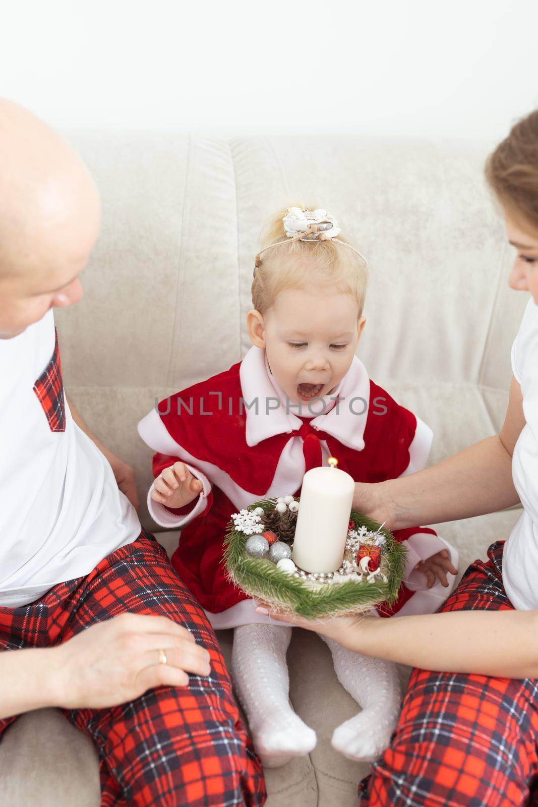 Baby child with hearing aid and cochlear implant having fun with parents in christmas room. Deaf and health