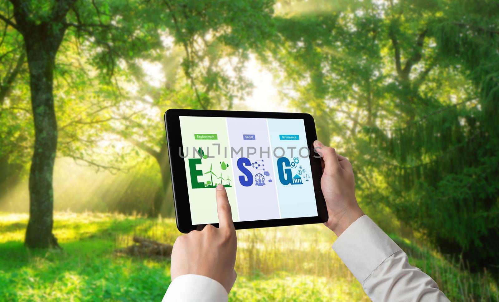 Green business transformation for environment saving and ESG business concept. Businessman using tablet to set corporate goal toward environmental friendly management and alternative clean energy use.
