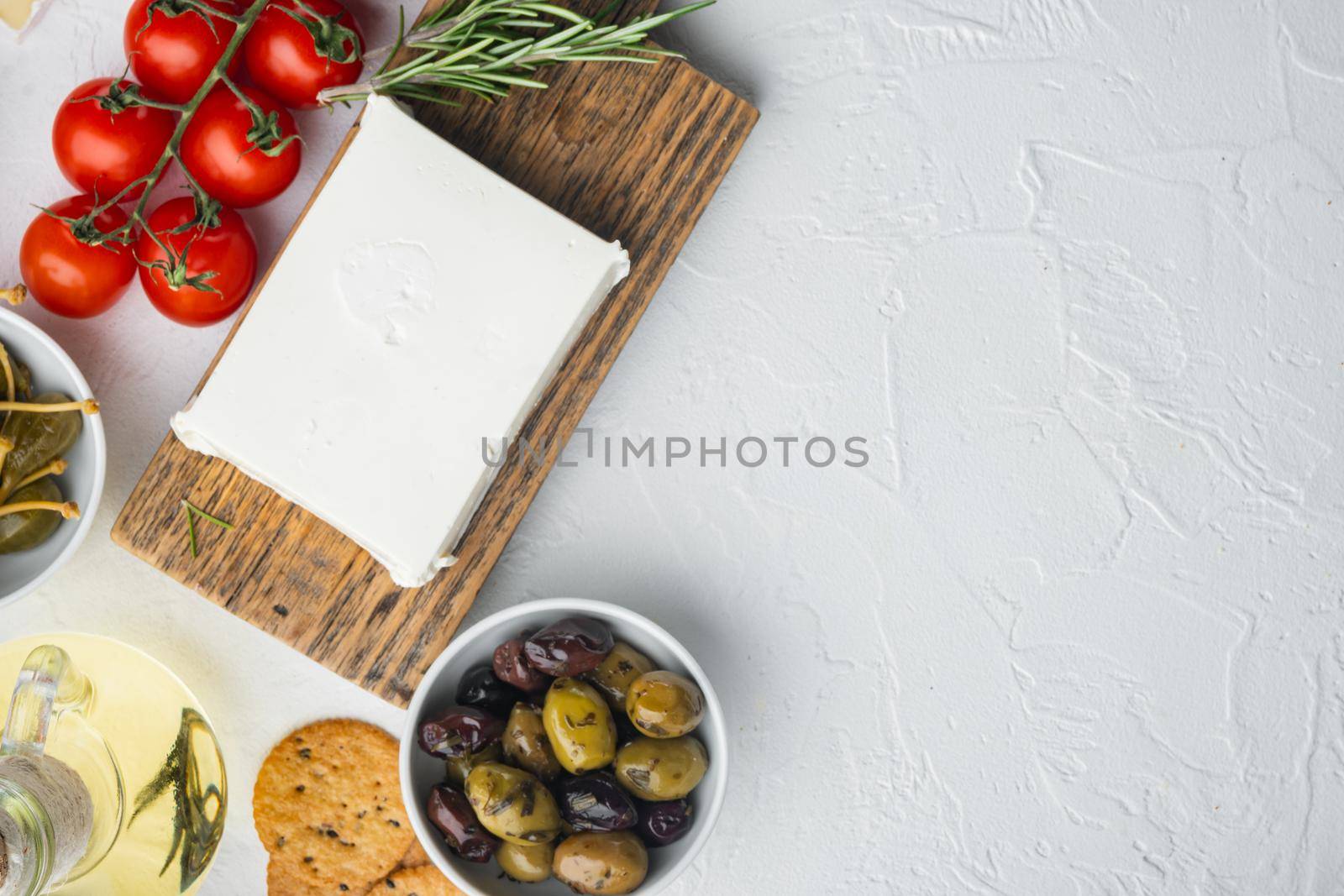 Greek salad main ingredients, fresh olives mix, feta cheese, tomatoes, on white background, flat lay with copy space for text by Ilianesolenyi