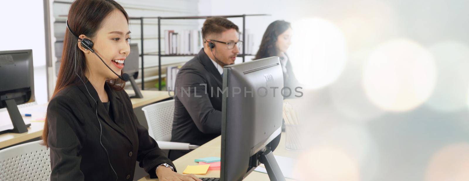 Business people wearing headset working in office to support remote customer or colleague. Call center, telemarketing, customer support agent provide service in broaden view .