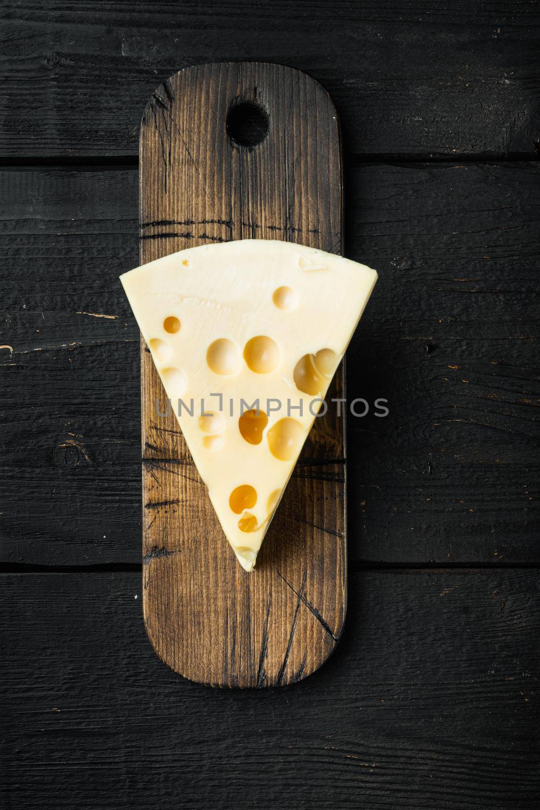 Maasdam cheese, on black wooden background, top view flat lay by Ilianesolenyi
