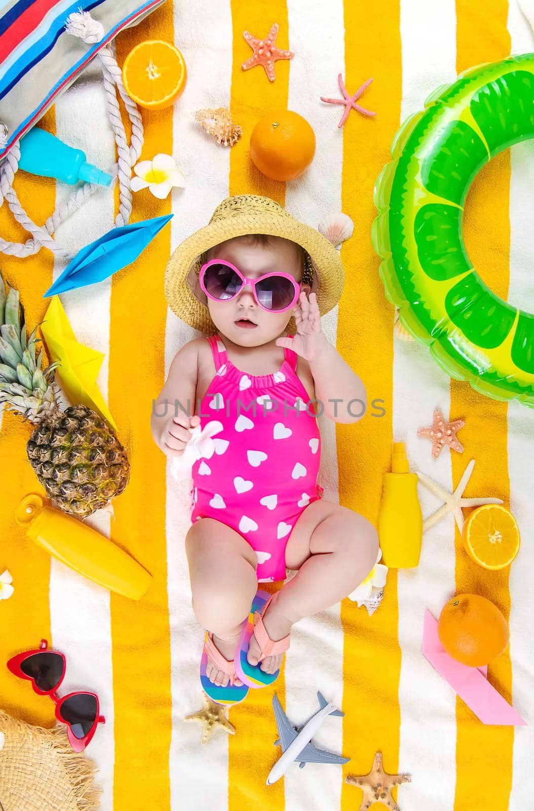 Baby on a beach towel at the sea. Selective focus. by yanadjana