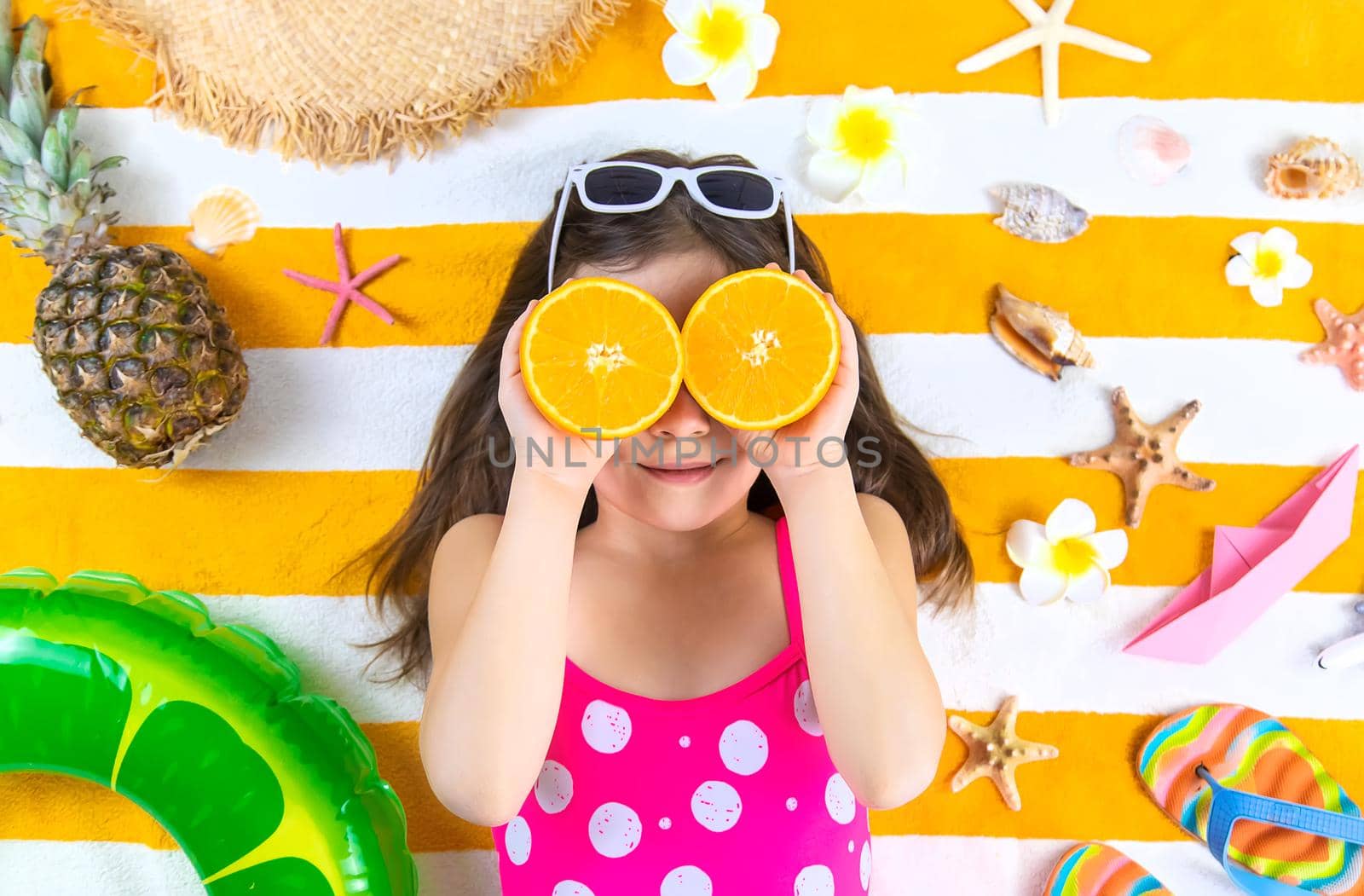 Child girl on a beach towel by the sea. Selective focus. Kid.