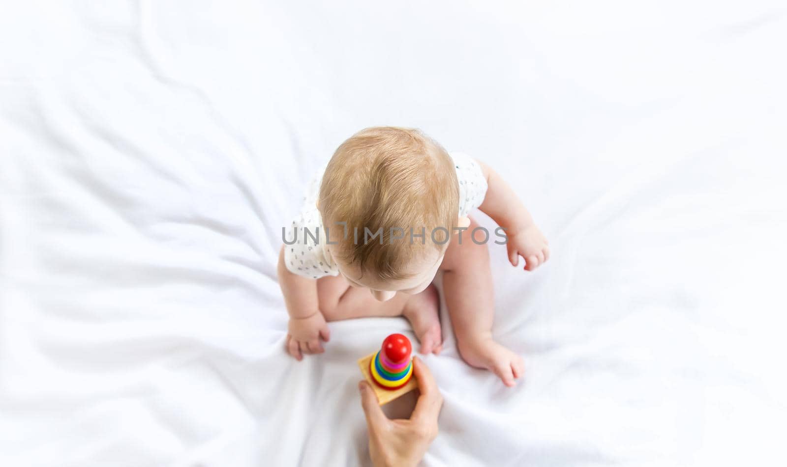 Baby plays with a pyramid at home. Selective focus. by yanadjana