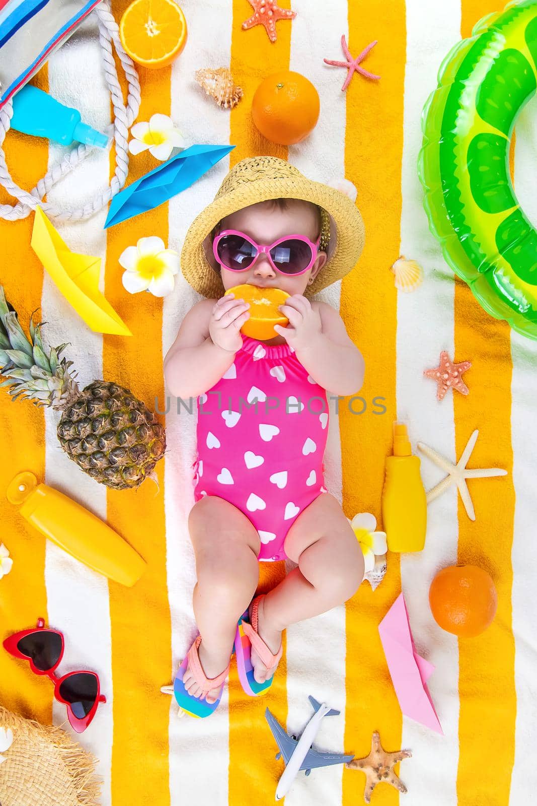 Baby on a beach towel at the sea. Selective focus. by yanadjana