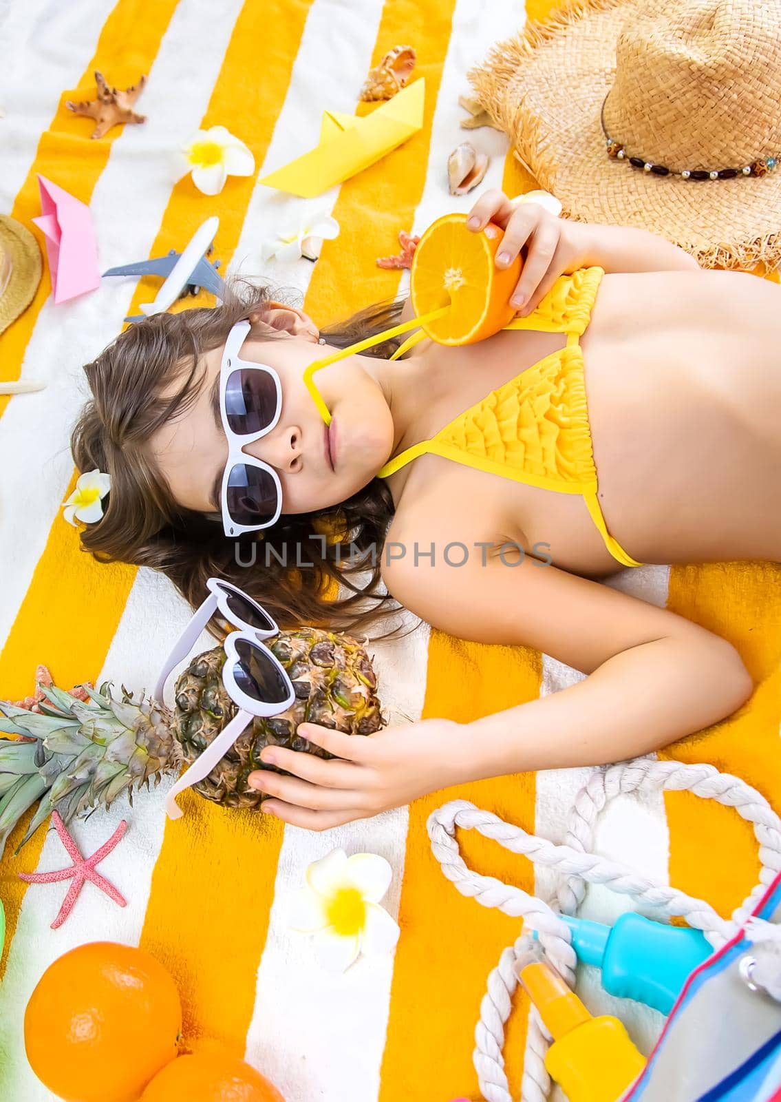 Child girl on a beach towel by the sea. Selective focus. Kid.