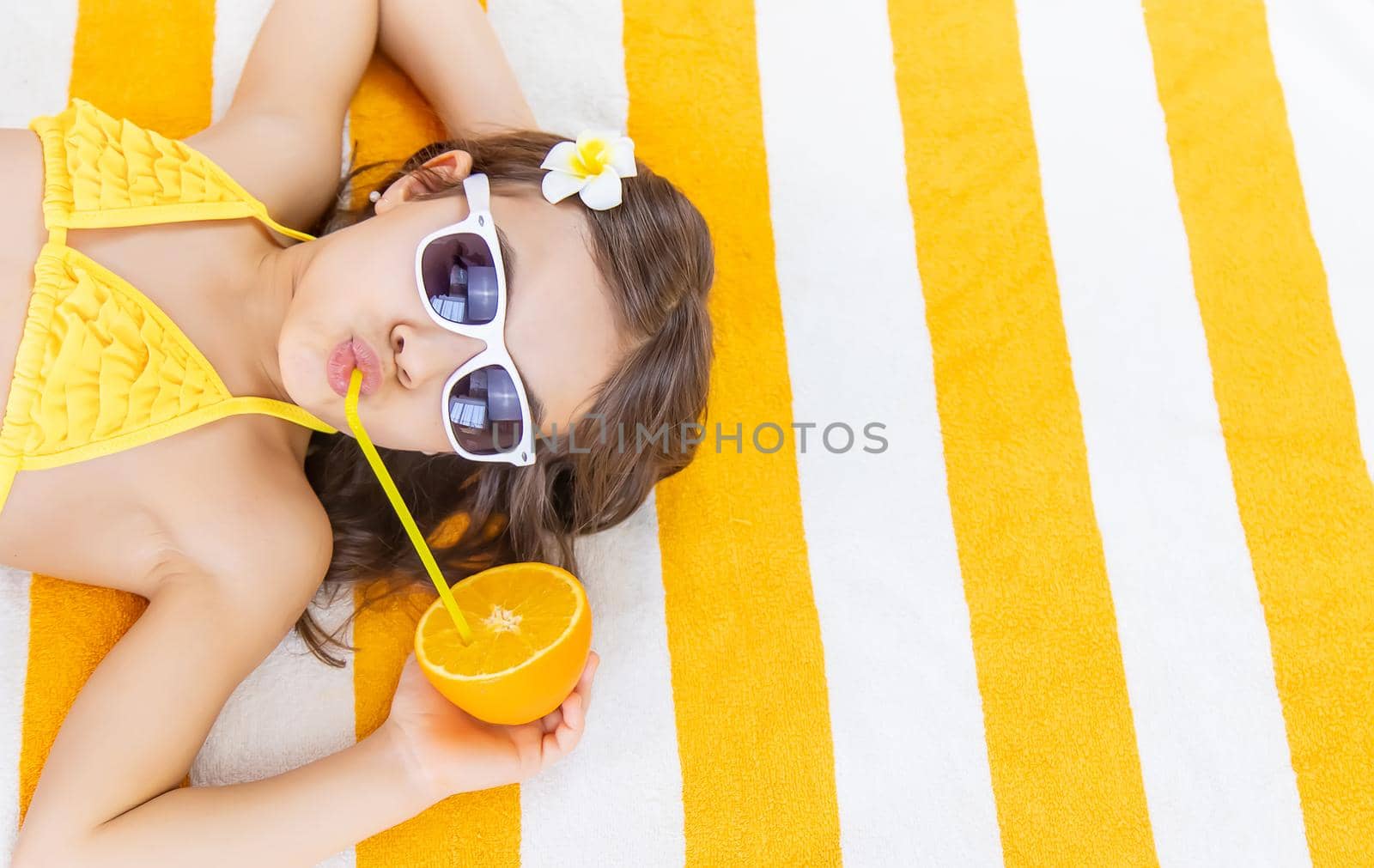 Child girl on a beach towel by the sea. Selective focus. Kid.