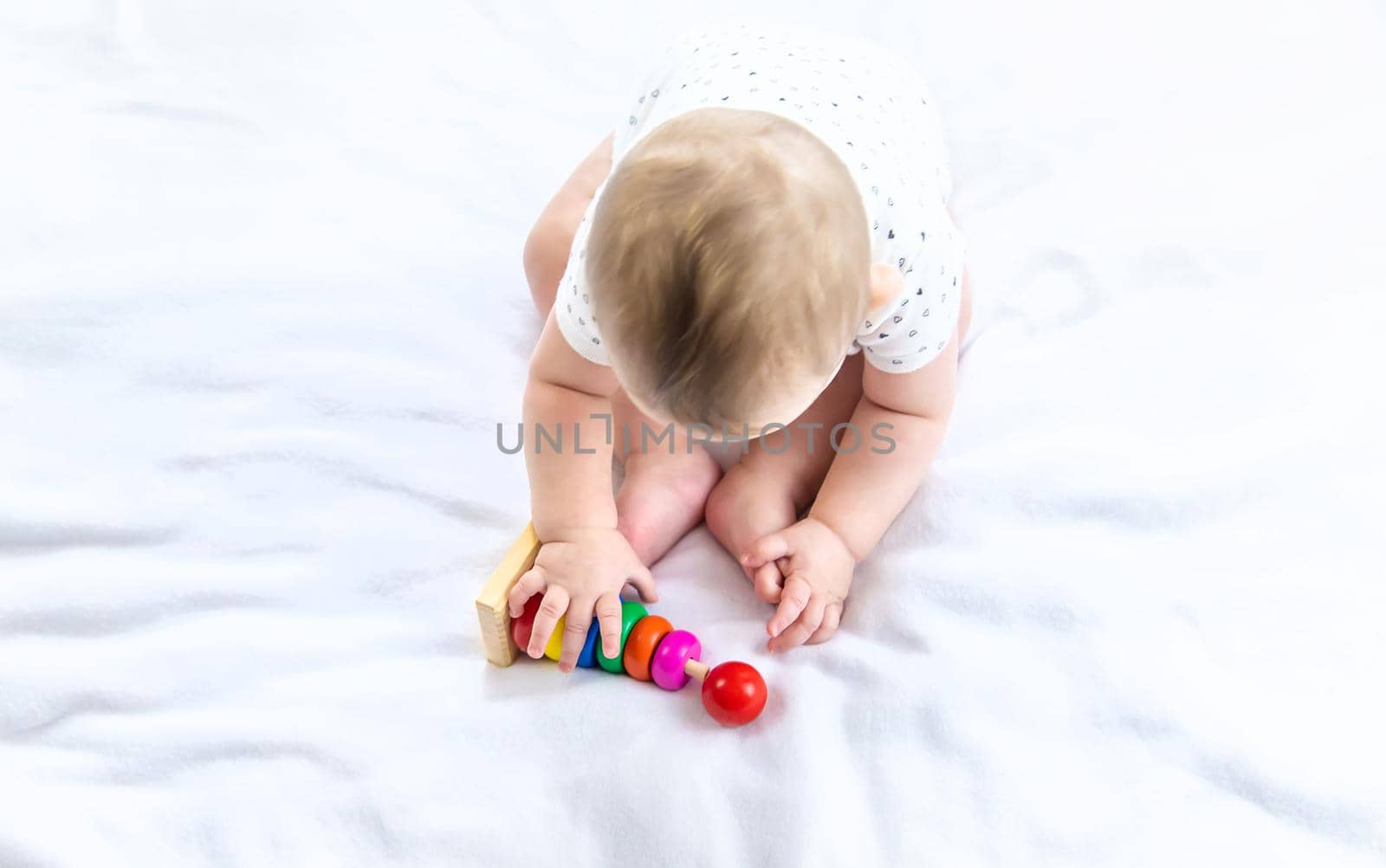 Baby plays with a pyramid at home. Selective focus. by yanadjana