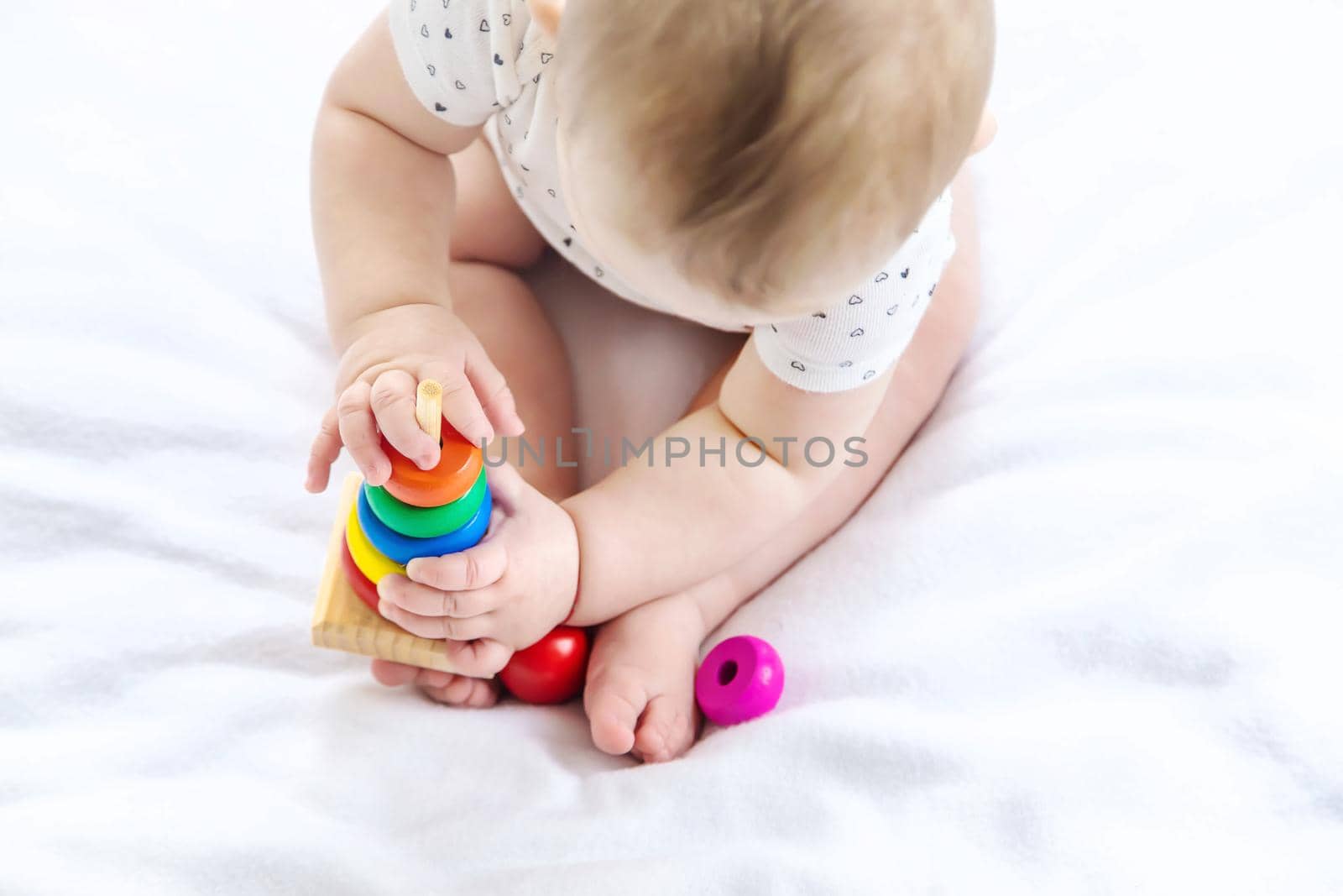 Baby plays with a pyramid at home. Selective focus. by yanadjana