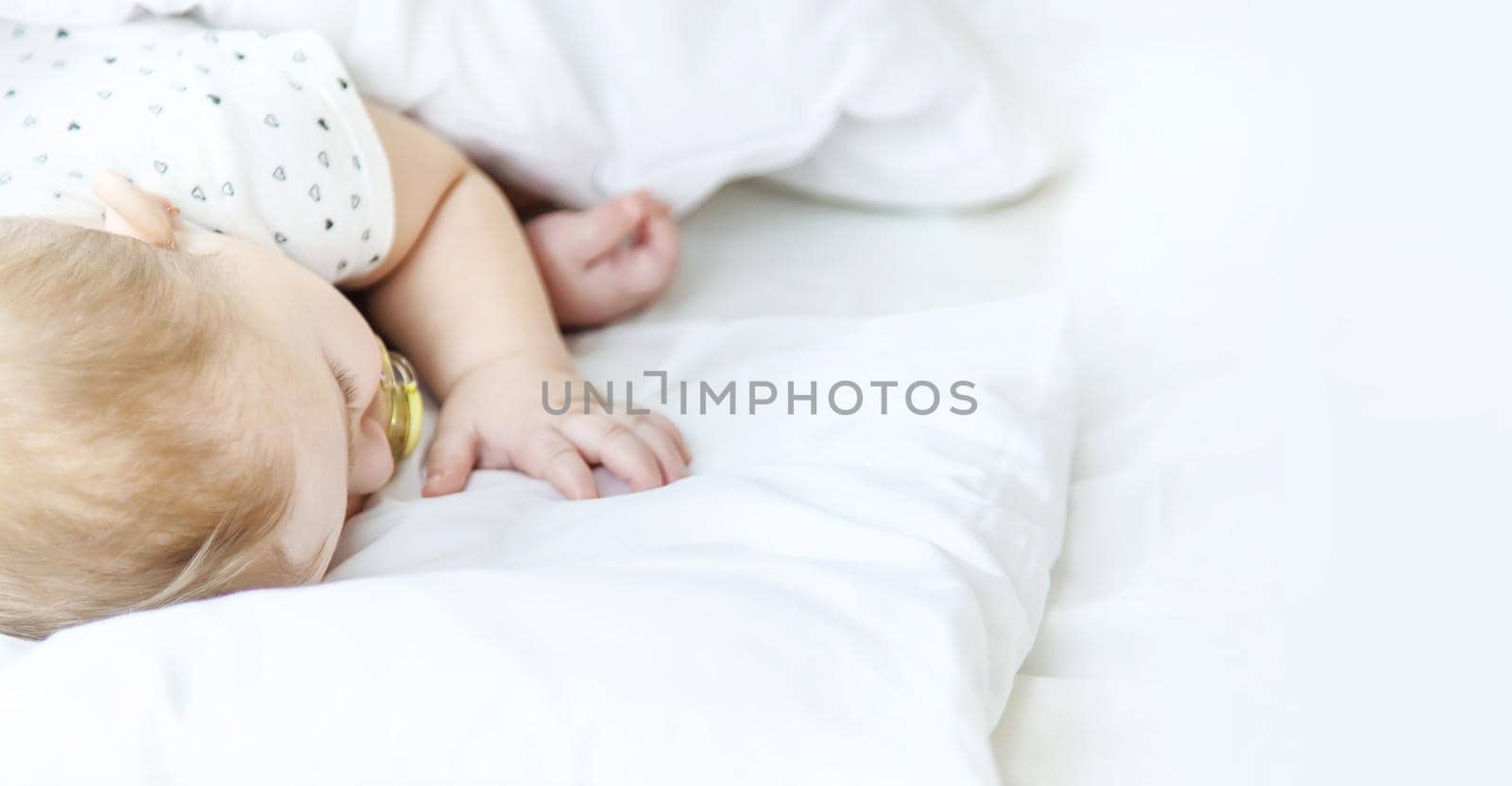 Baby sleeps on a white bed. Selective focus. Child.