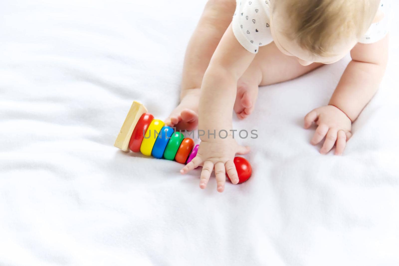 Baby plays with a pyramid at home. Selective focus. by yanadjana