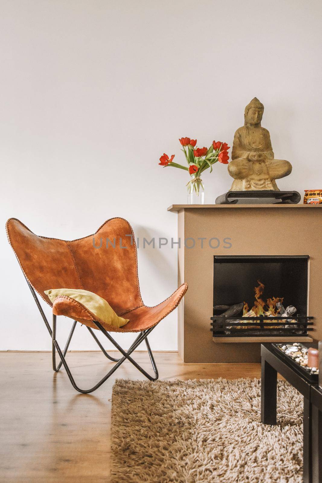 A stylish brown armchair near the fireplace