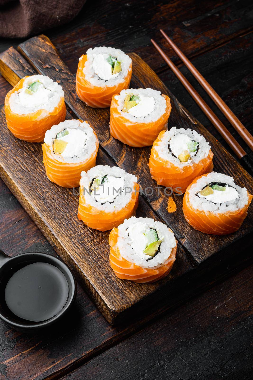 Fresh sushi rolls with wasabi and ginger, on old dark wooden table background by Ilianesolenyi