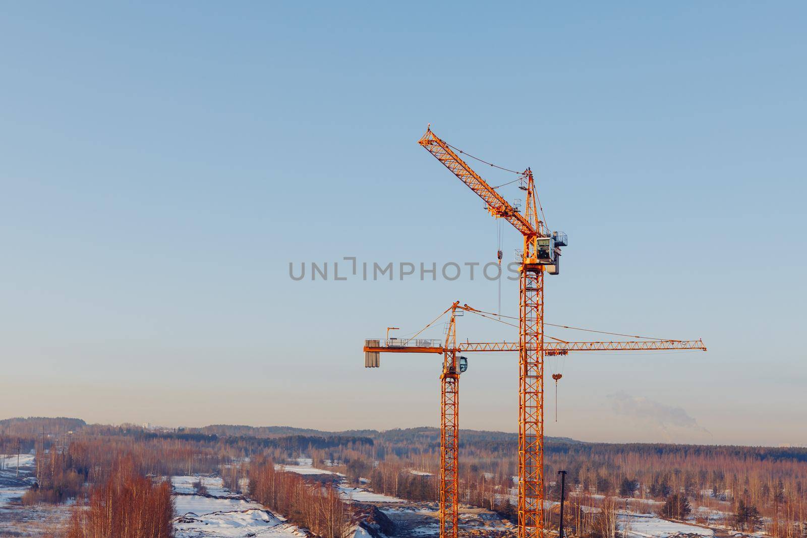 building cranes at the construction site on blue sky background by nikkytok