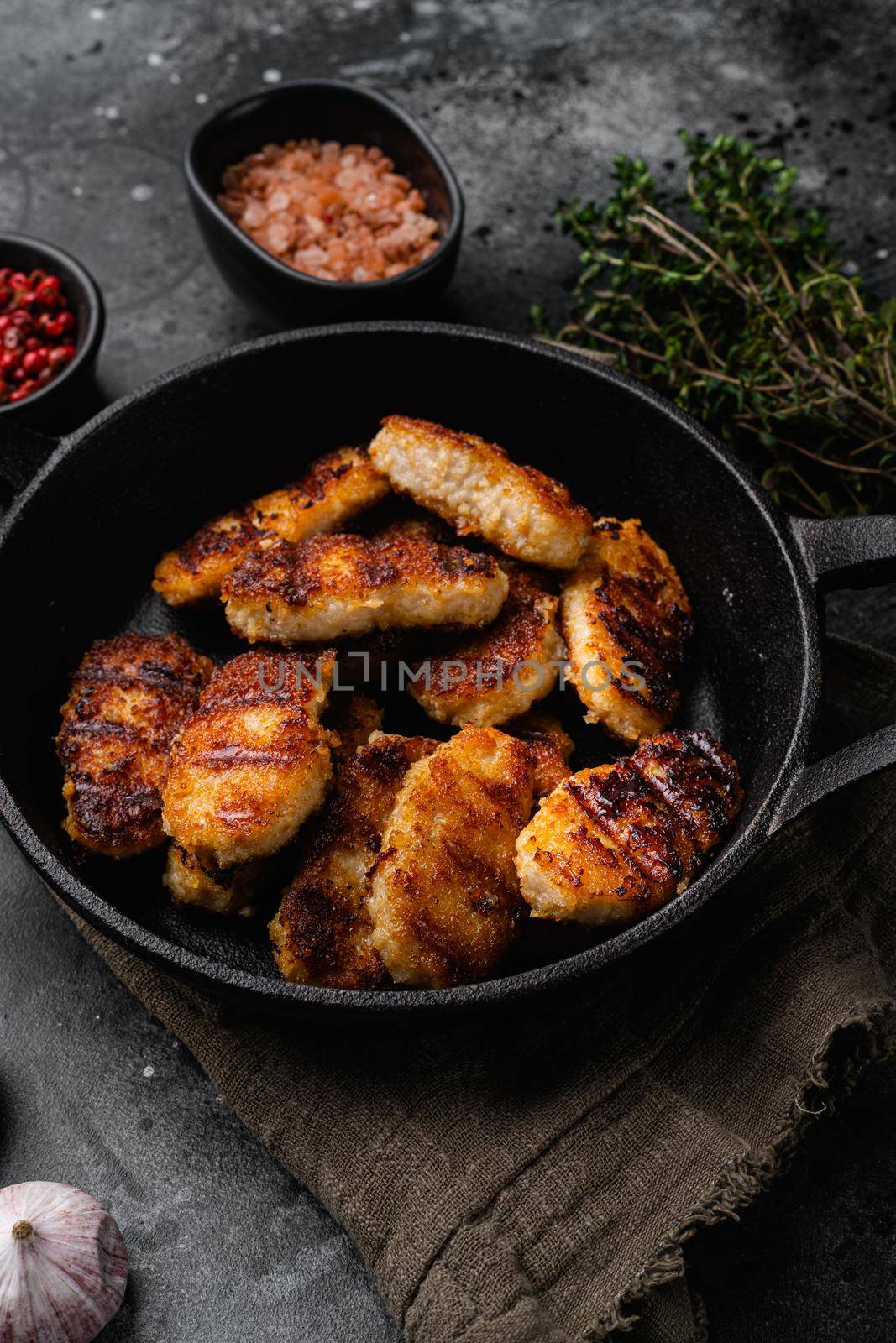 Tasty fried chicken nuggets, on black dark stone table background by Ilianesolenyi