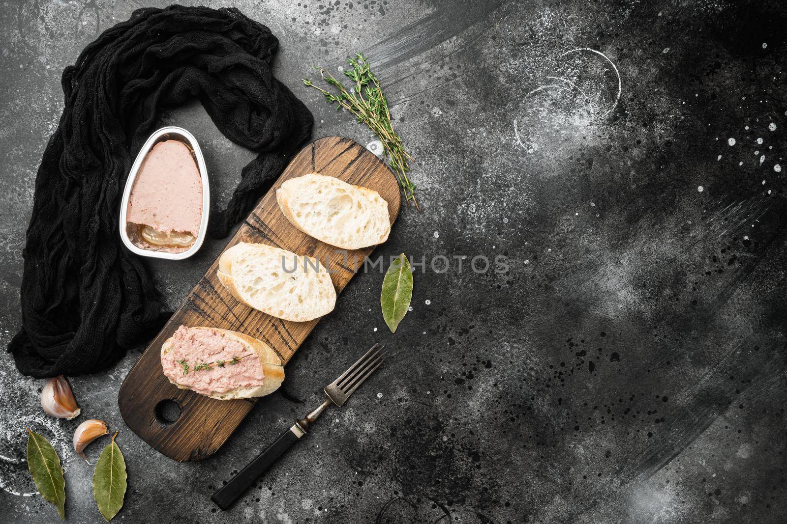 Fresh chicken liver pate from can on bread set, on black dark stone table background, top view flat lay, with copy space for text