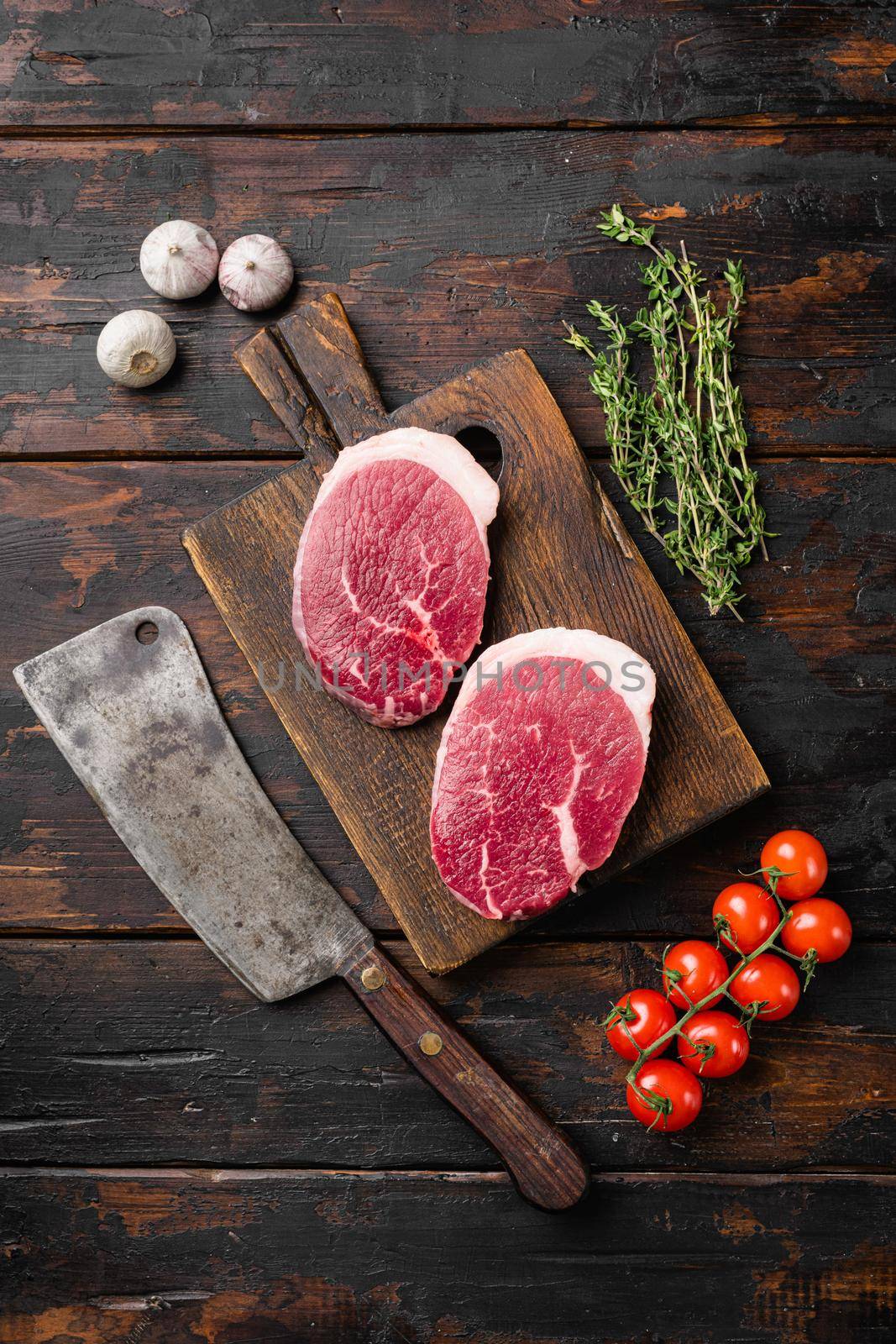 Raw tenderloin steak, on old dark wooden table background, top view flat lay, with copy space for text by Ilianesolenyi