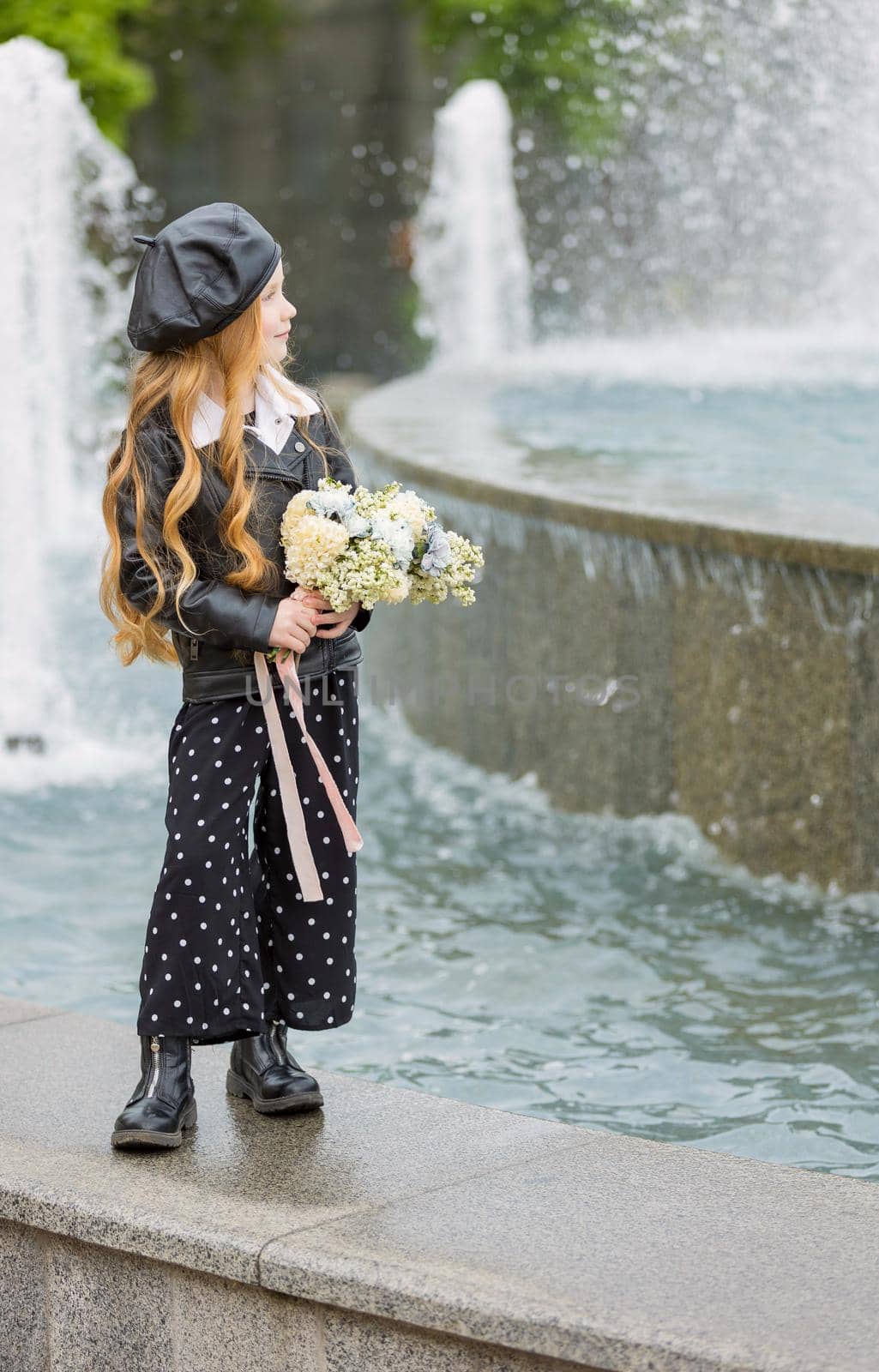 girl with a bouquet of flowers near the fountain