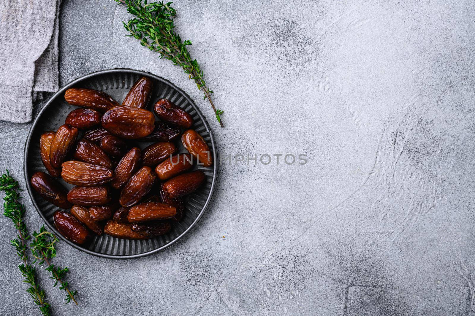 Dried date palm fruits set, on gray stone table background, top view flat lay, with copy space for text by Ilianesolenyi