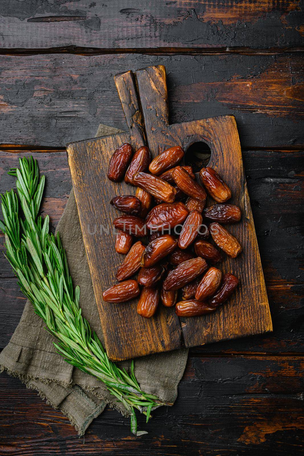 Traditional arabic dry dates, on old dark wooden table background, top view flat lay