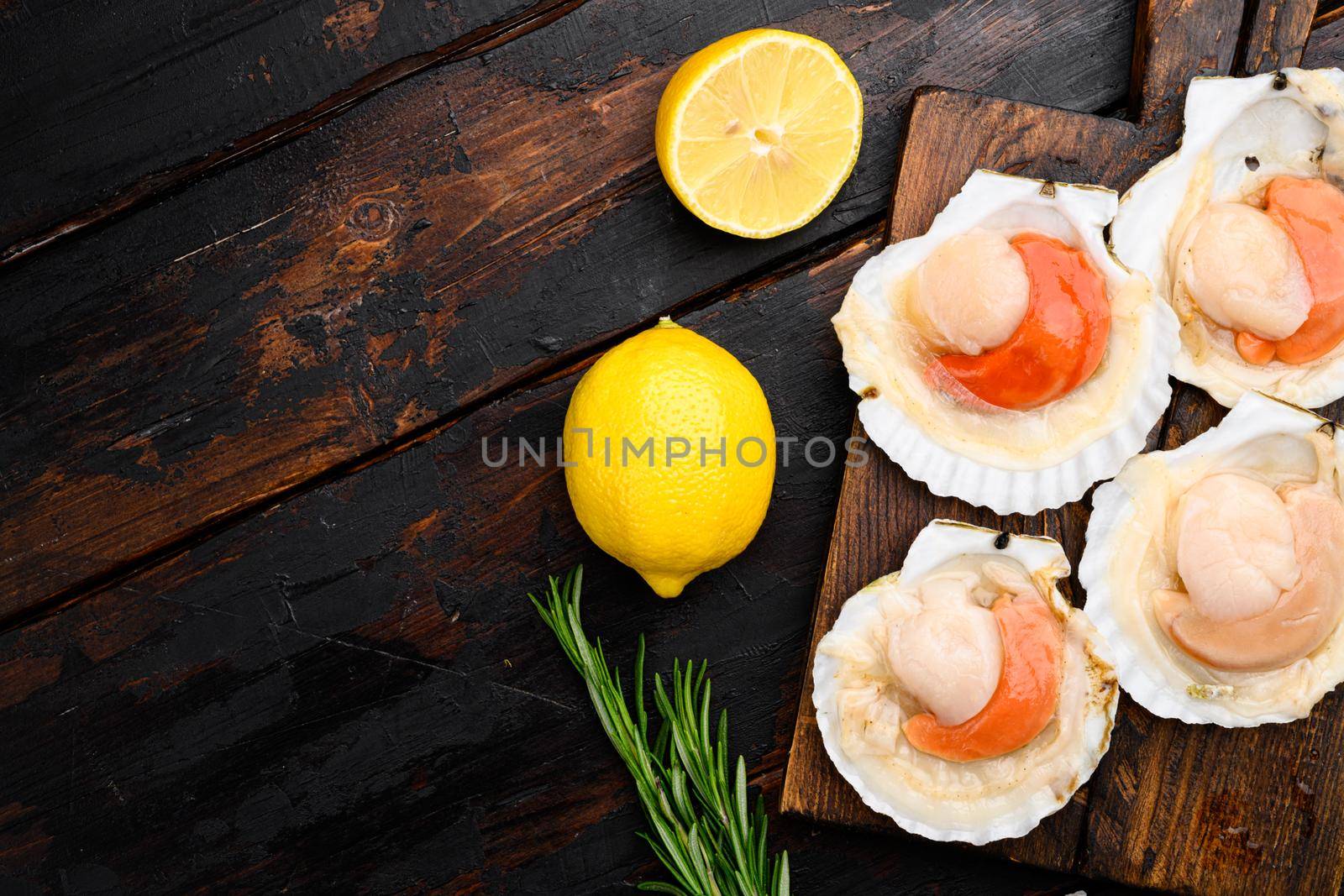 Seafood organic scallops, on old dark wooden table background, top view flat lay, with copy space for text by Ilianesolenyi