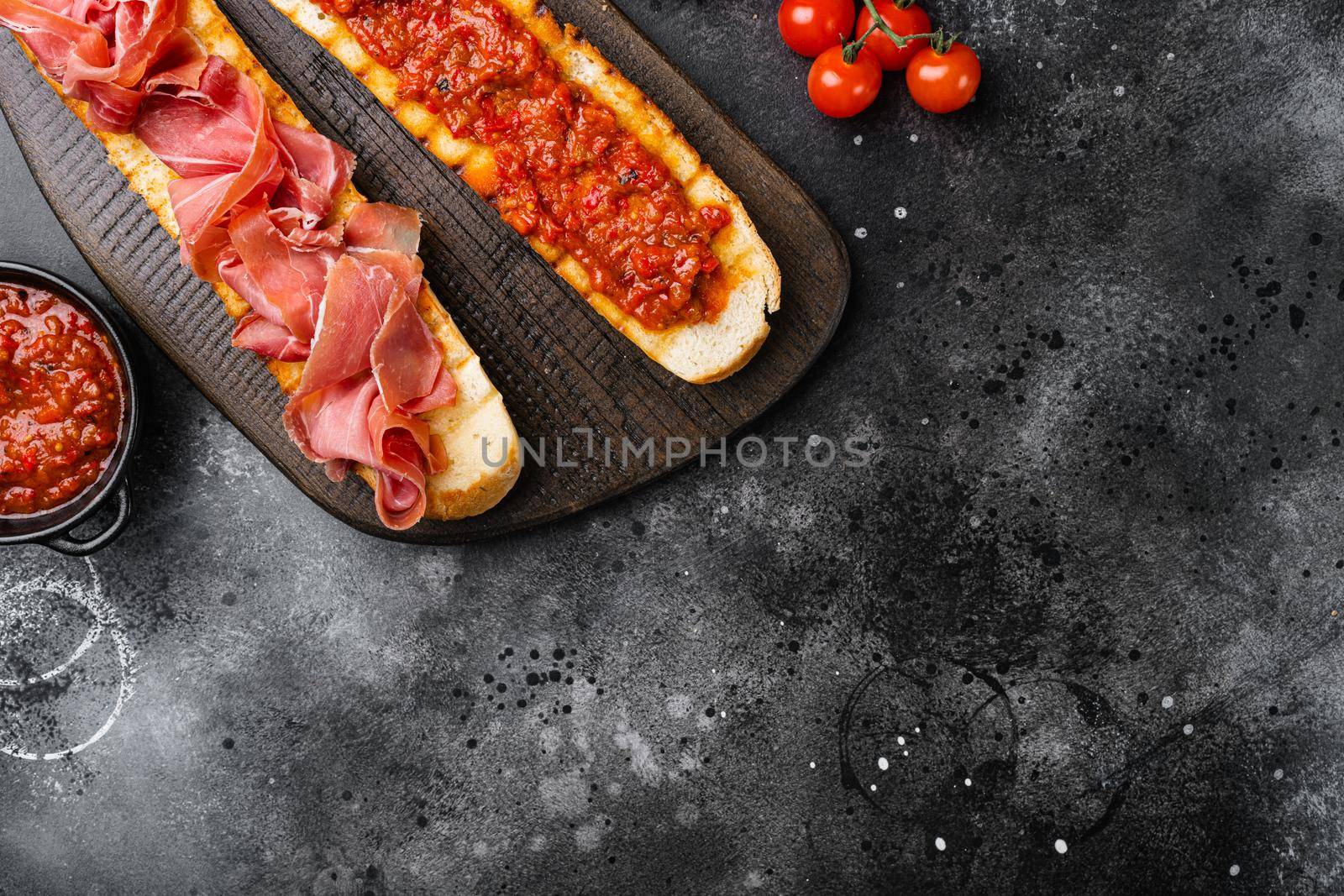 Spanish tomato and jamon toast, traditional breakfast set, on black dark stone table background, top view flat lay, with copy space for text by Ilianesolenyi