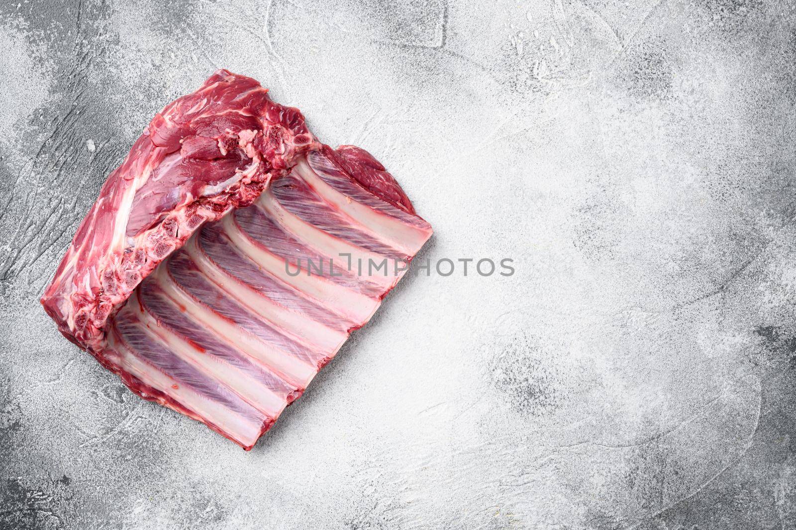 Lamb ribs cooking. Raw rack of lamb meat, on gray stone table background, top view flat lay, with copy space for text by Ilianesolenyi