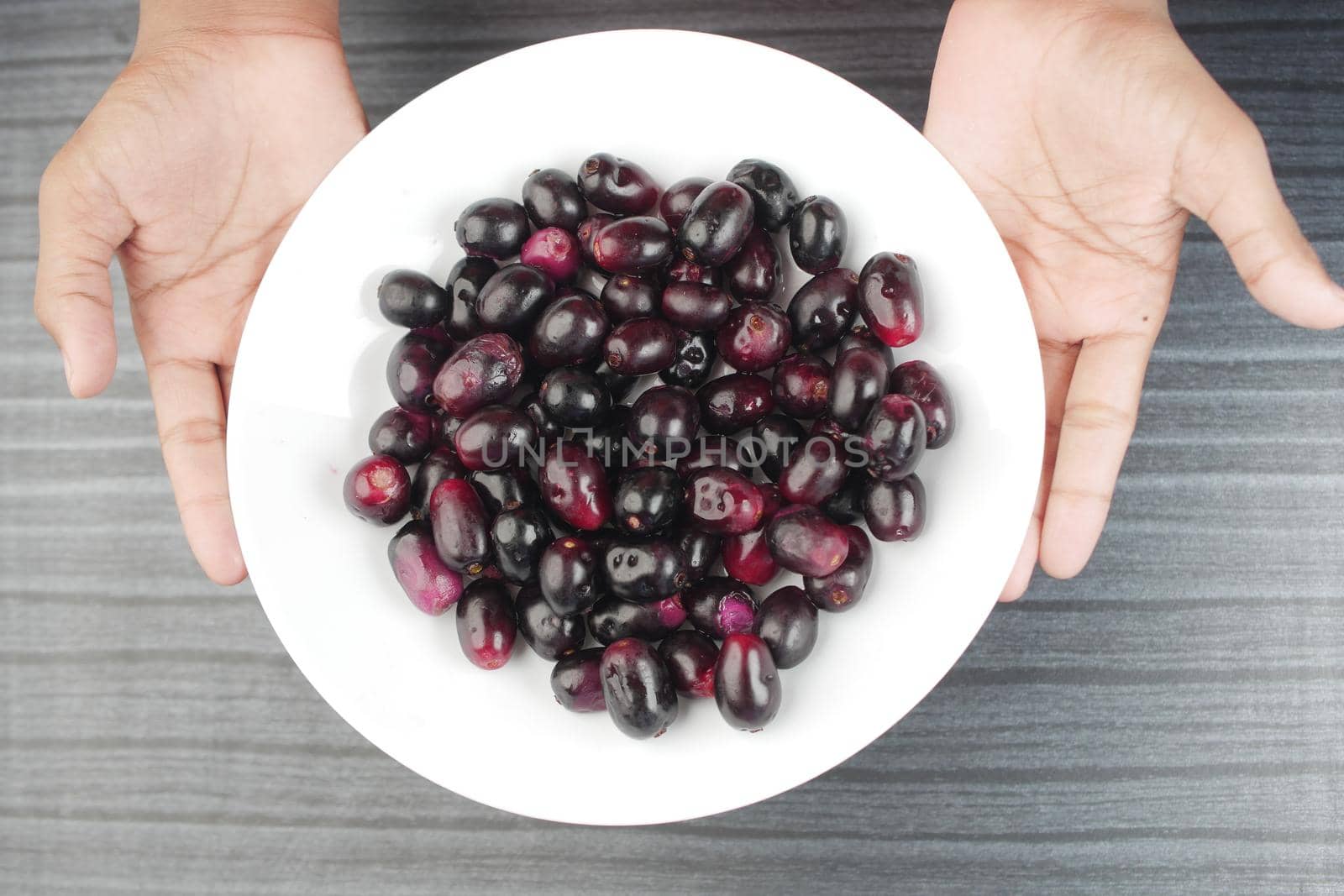 top view of black plum on a plate
